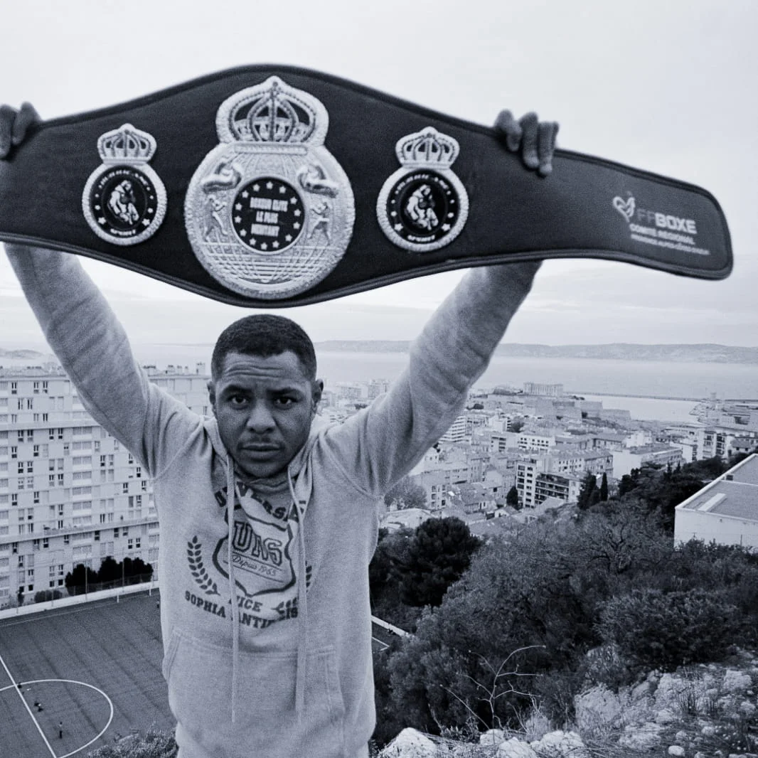 Maho Bah-Villemagne, boxeur français, brandit sa ceinture décernée par la FFBOXE