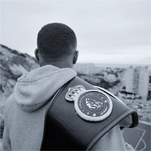 Maho Bah-Villemagne, boxeur français, à la dos tourné à la caméra avec la ceinture décernée par le FFBoxe sur son épaule.